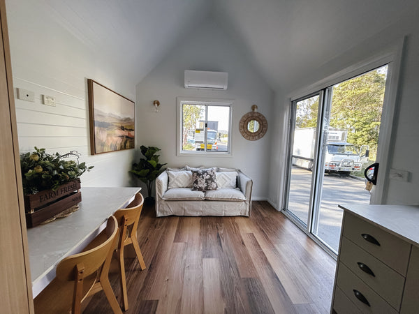 Modern interior of a home with a dining area, living room, and large windows.